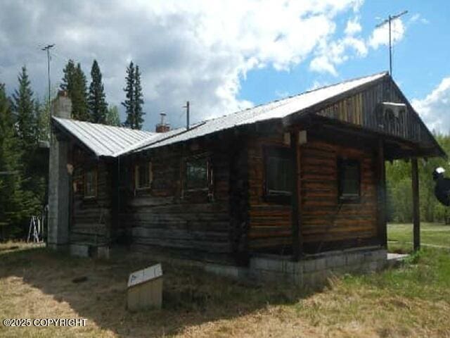 2030 Haydon Ct, Fairbanks, AK 99701 - view of home's exterior with a chimney, a metal roof, and log siding