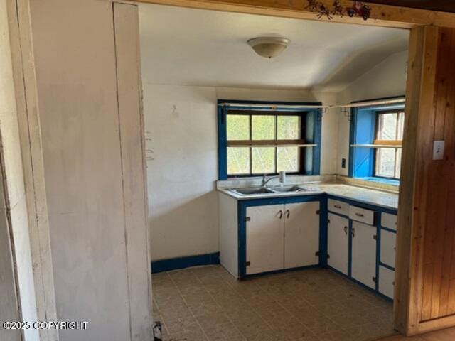 2030 Haydon Ct, Fairbanks, AK 99701 - kitchen featuring lofted ceiling, light countertops, and white cabinetry