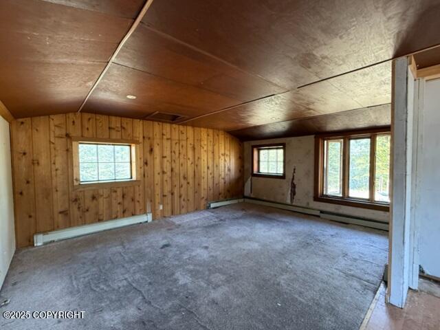 2030 Haydon Ct, Fairbanks, AK 99701 - unfurnished room with baseboard heating, lofted ceiling, a baseboard heating unit, carpet flooring, and wood walls