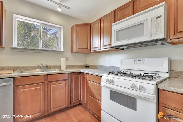 3150 E Escondido Ave, Wasilla, AK 99654 - kitchen featuring white appliances, brown cabinetry, light wood finished floors, light countertops, and vaulted ceiling