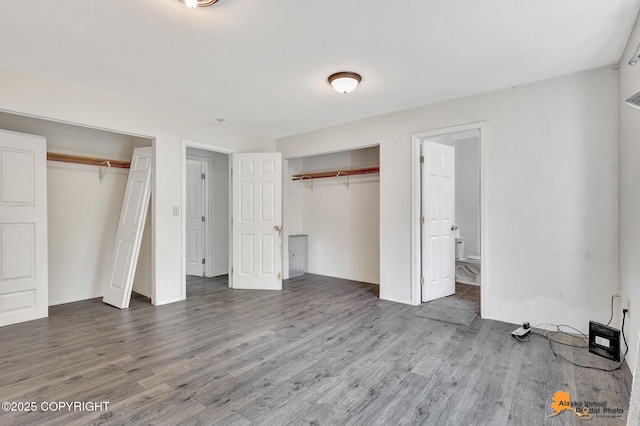 3150 E Escondido Ave, Wasilla, AK 99654 - unfurnished bedroom featuring two closets, wood finished floors, and connected bathroom