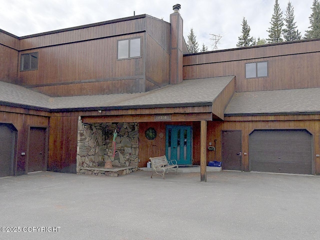 4376 Dartmouth Dr # 9, Fairbanks, AK 99709 - view of front facade with a garage, a chimney, and a shingled roof