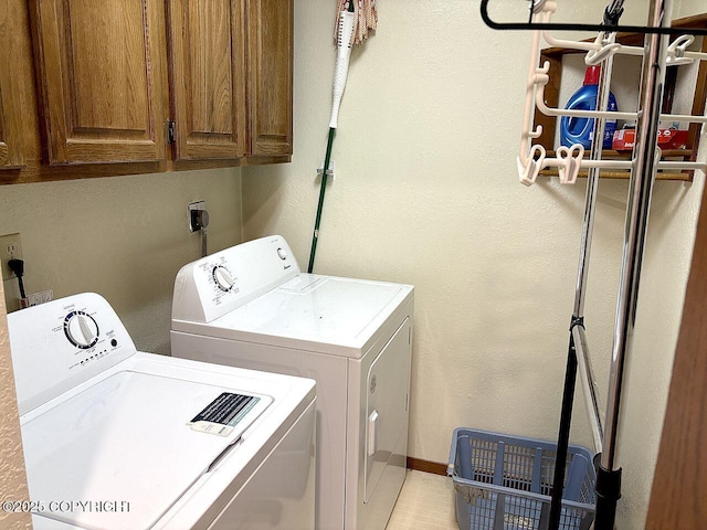 4376 Dartmouth Dr # 9, Fairbanks, AK 99709 - laundry area featuring washing machine and clothes dryer, cabinet space, and a textured wall