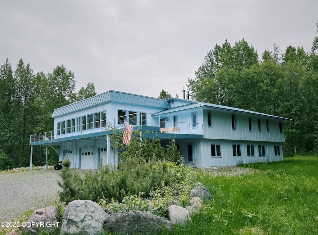 22135 Aurora Borealis Rd, Chugiak, AK 99567 - back of house featuring driveway, an attached garage, and a metal roof