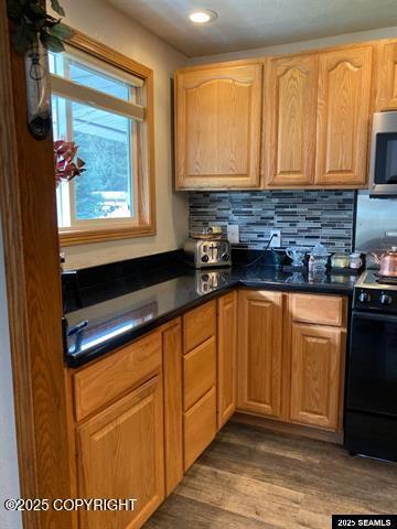 4128 Taku Blvd, Juneau, AK 99801 - kitchen featuring stove, stainless steel microwave, dark countertops, decorative backsplash, and recessed lighting