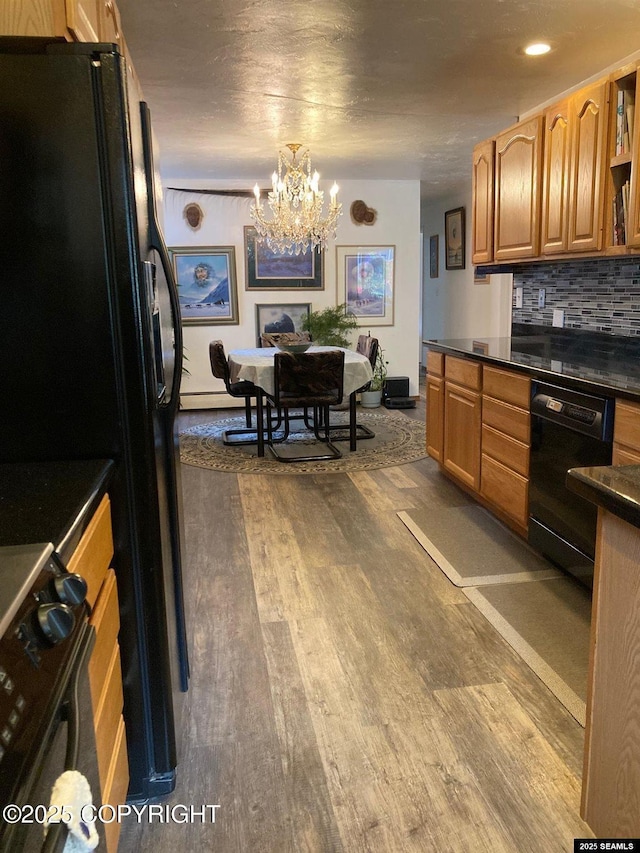 4128 Taku Blvd, Juneau, AK 99801 - kitchen featuring black appliances, a chandelier, dark wood-style flooring, dark countertops, and backsplash