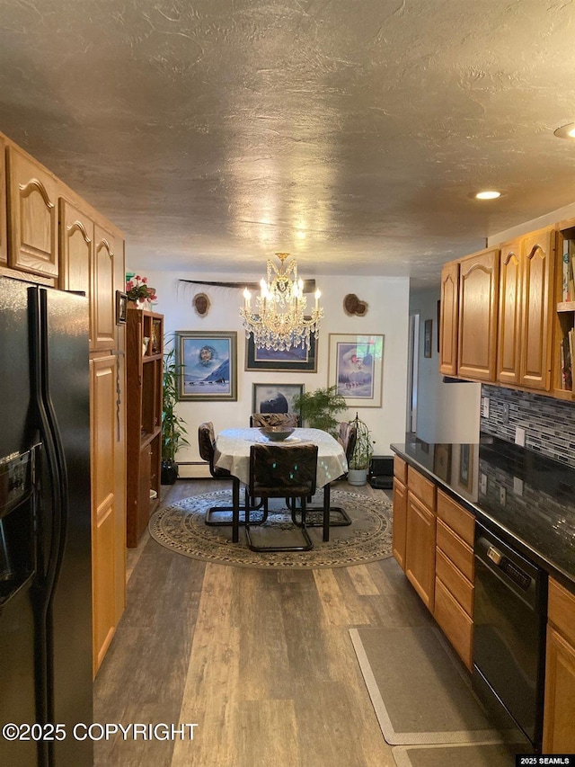 4128 Taku Blvd, Juneau, AK 99801 - kitchen with black appliances, a chandelier, dark countertops, dark wood-style floors, and backsplash