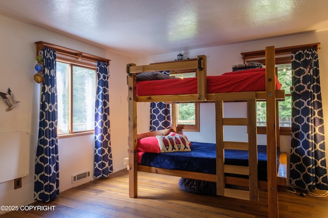 413 N Higgins Ct, Ketchikan, AK 99901 - bedroom featuring wood finished floors, multiple windows, and a textured ceiling
