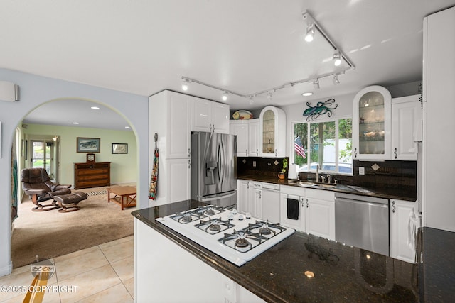 14121 Sunview Dr, Anchorage, AK 99515 - kitchen featuring stainless steel appliances, arched walkways, light tile patterned flooring, and white cabinetry