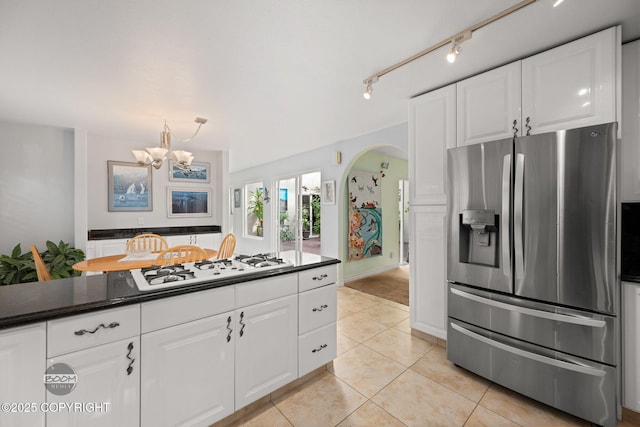 14121 Sunview Dr, Anchorage, AK 99515 - kitchen featuring stainless steel fridge, arched walkways, white gas stovetop, and dark countertops