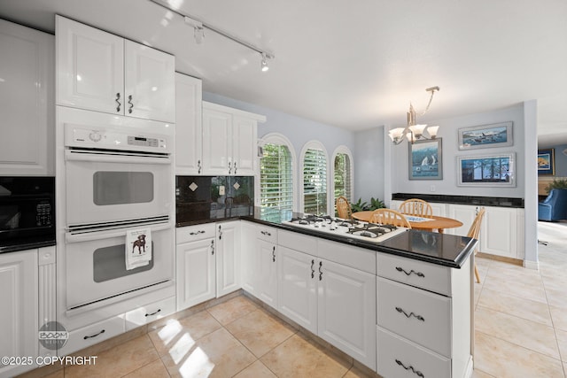14121 Sunview Dr, Anchorage, AK 99515 - kitchen featuring white appliances, a peninsula, a chandelier, light tile patterned flooring, and white cabinetry