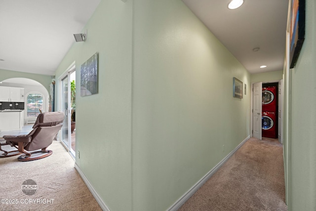 14121 Sunview Dr, Anchorage, AK 99515 - corridor with light carpet, stacked washer / dryer, arched walkways, and recessed lighting