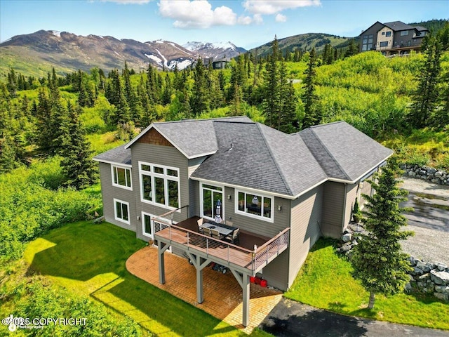 16071 Mountain Air Dr, Anchorage, AK 99516 - back of house with a deck with mountain view, roof with shingles, and a yard