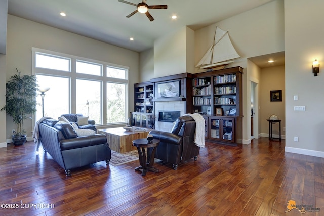16071 Mountain Air Dr, Anchorage, AK 99516 - living area featuring a fireplace, ceiling fan, a towering ceiling, wood finished floors, and recessed lighting