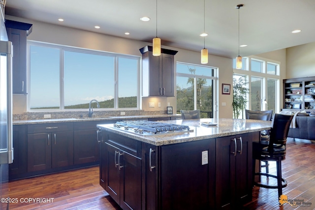 16071 Mountain Air Dr, Anchorage, AK 99516 - kitchen featuring stainless steel gas cooktop, a breakfast bar, a kitchen island, dark wood-type flooring, and recessed lighting