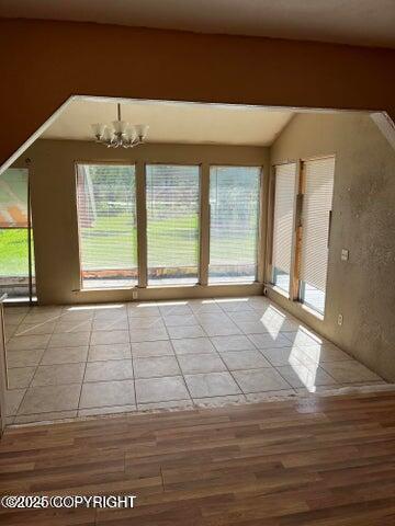 53245 Coyote Ln, Nikiski/North Kenai, AK 99611 - spare room featuring plenty of natural light, wood finished floors, and a chandelier
