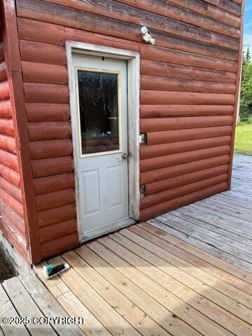 53245 Coyote Ln, Nikiski/North Kenai, AK 99611 - doorway to property featuring log veneer siding and a wooden deck