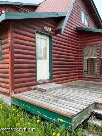 53245 Coyote Ln, Nikiski/North Kenai, AK 99611 - view of exterior entry with log veneer siding and a deck