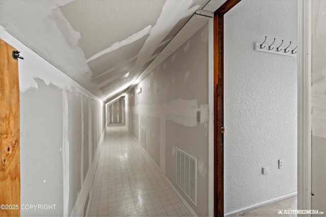 19712 Chugach Park Dr, Eagle River, AK 99567 - hall featuring a textured wall, lofted ceiling, and tile patterned flooring