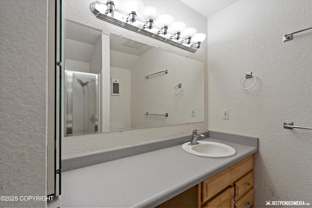 19712 Chugach Park Dr, Eagle River, AK 99567 - full bath with a textured wall, vanity, and a stall shower