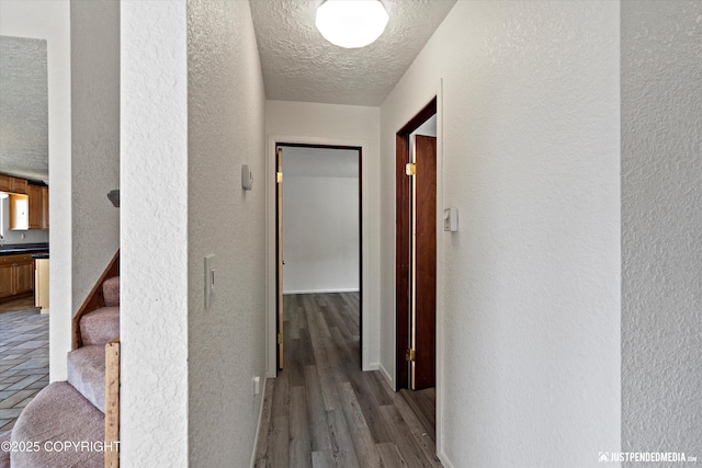 19712 Chugach Park Dr, Eagle River, AK 99567 - hallway with a textured wall, a textured ceiling, stairway, and wood finished floors