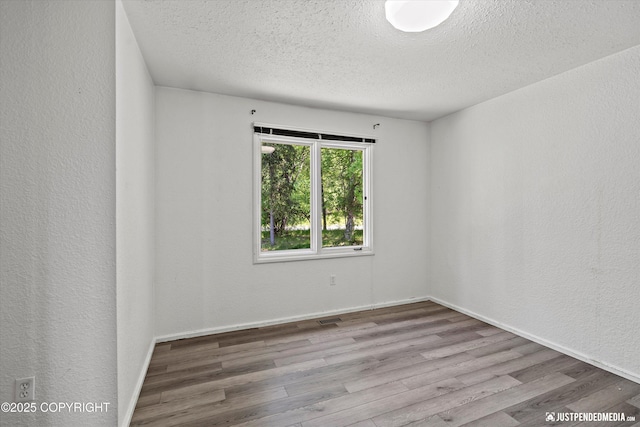 19712 Chugach Park Dr, Eagle River, AK 99567 - spare room featuring a textured ceiling and wood finished floors