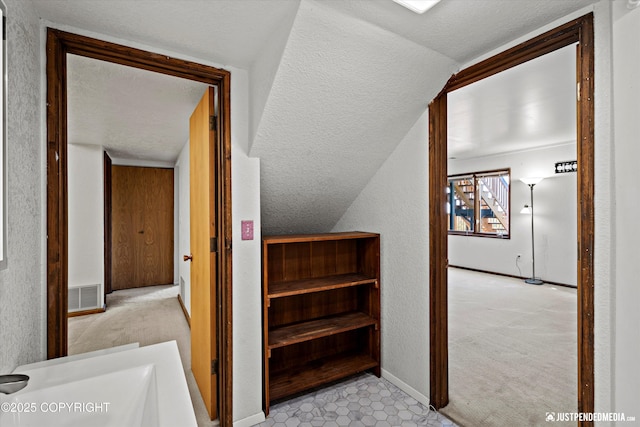 19712 Chugach Park Dr, Eagle River, AK 99567 - staircase with a textured ceiling, carpet, vaulted ceiling, and a textured wall
