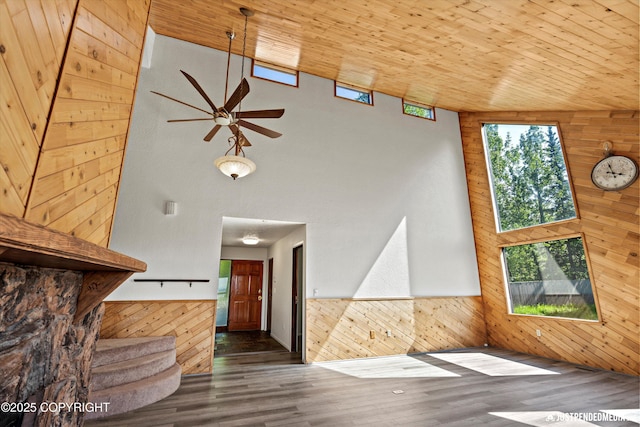 19712 Chugach Park Dr, Eagle River, AK 99567 - unfurnished living room with wood walls, a towering ceiling, a ceiling fan, wood finished floors, and wood ceiling
