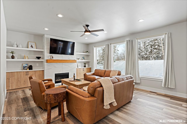 9203 Strutz Ave, Anchorage, AK 99507 - living room with a ceiling fan, a premium fireplace, wood finished floors, recessed lighting, and built in shelves