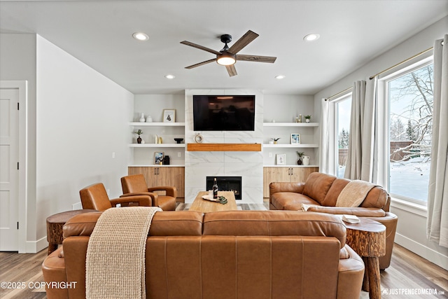 9203 Strutz Ave, Anchorage, AK 99507 - living area with ceiling fan, light wood-style floors, a fireplace, recessed lighting, and built in shelves