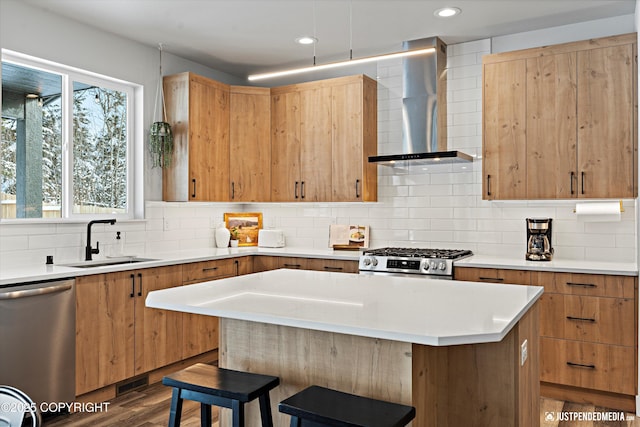 9203 Strutz Ave, Anchorage, AK 99507 - kitchen featuring wall chimney range hood, appliances with stainless steel finishes, a kitchen bar, decorative backsplash, and light countertops