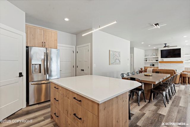 9203 Strutz Ave, Anchorage, AK 99507 - kitchen with stainless steel fridge, light wood-style flooring, a ceiling fan, a kitchen island, and light brown cabinetry