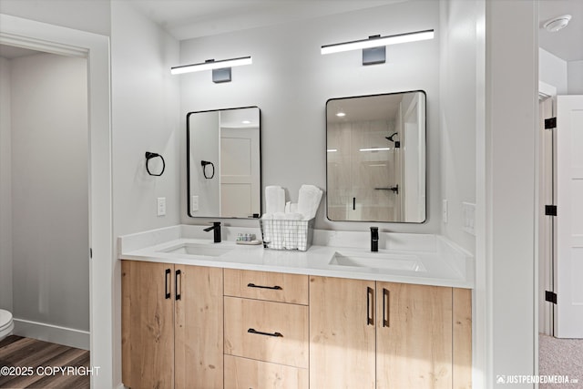 9203 Strutz Ave, Anchorage, AK 99507 - bathroom featuring double vanity, tiled shower, and wood finished floors