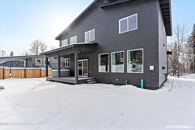 9203 Strutz Ave, Anchorage, AK 99507 - snow covered rear of property featuring a deck and a hot tub