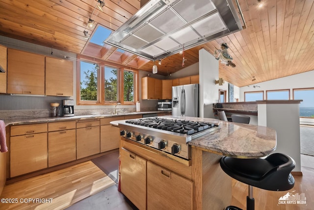 11411 Snowline Dr, Anchorage, AK 99507 - kitchen with appliances with stainless steel finishes, lofted ceiling, wooden ceiling, a breakfast bar area, and light stone counters