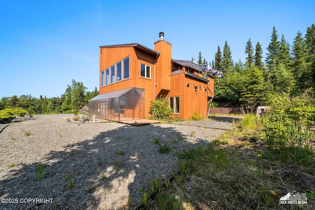 11411 Snowline Dr, Anchorage, AK 99507 - rear view of property with a chimney