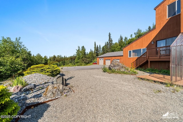 11411 Snowline Dr, Anchorage, AK 99507 - view of yard featuring a garage, stairway, driveway, and a wooden deck