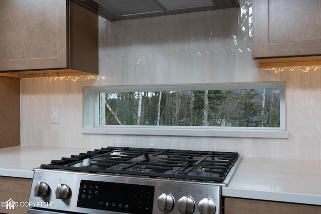 17939 Yellowstone Dr, Eagle River, AK 99577 - kitchen view of stainless steel range with gas stovetop, light countertops, tasteful backsplash, and exhaust hood