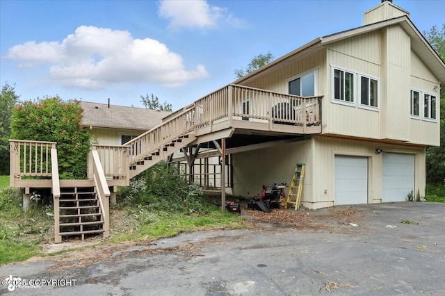 1447 N Ranch Rd, Palmer, AK 99645 - back of property with stairway, a garage, a wooden deck, and a chimney