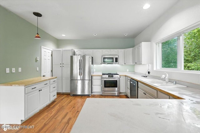 1447 N Ranch Rd, Palmer, AK 99645 - kitchen featuring stainless steel appliances, light wood-style floors, decorative light fixtures, white cabinetry, and recessed lighting
