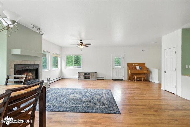 1447 N Ranch Rd, Palmer, AK 99645 - living area featuring a baseboard radiator, ceiling fan, wood finished floors, and a tile fireplace