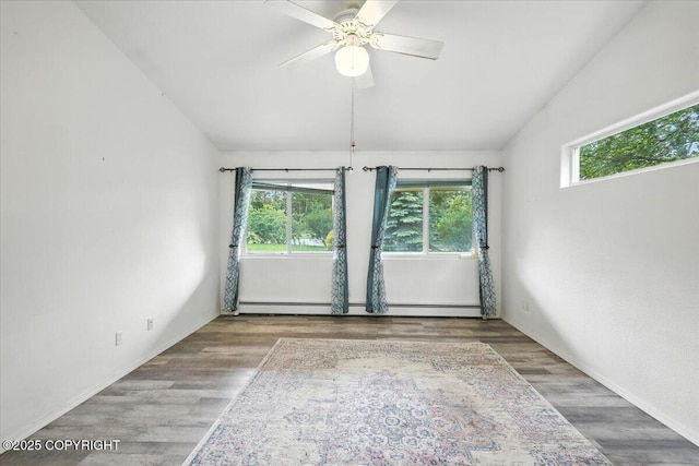 1447 N Ranch Rd, Palmer, AK 99645 - unfurnished room featuring a baseboard heating unit, wood finished floors, and ceiling fan