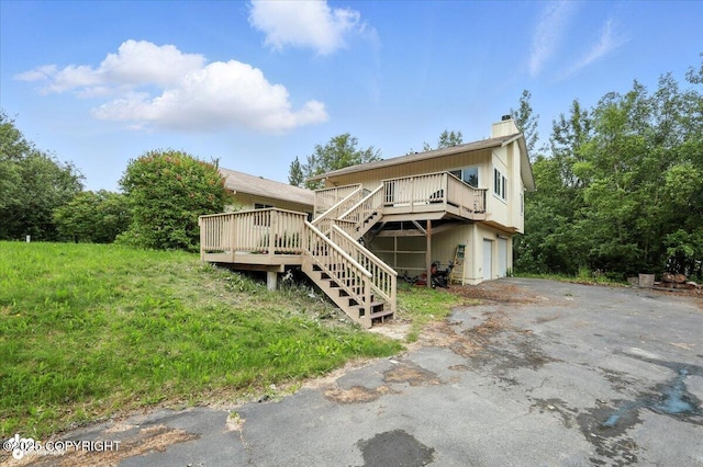 1447 N Ranch Rd, Palmer, AK 99645 - view of front of property featuring a garage, a wooden deck, asphalt driveway, stairway, and a chimney