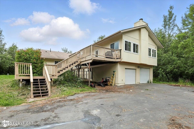 1447 N Ranch Rd, Palmer, AK 99645 - view of property exterior with stairway, a garage, a wooden deck, and a chimney