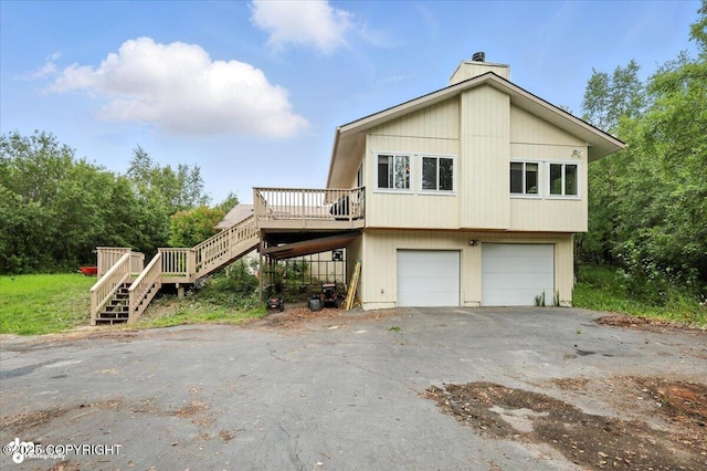 1447 N Ranch Rd, Palmer, AK 99645 - view of home's exterior with stairway, a garage, a wooden deck, a chimney, and asphalt driveway