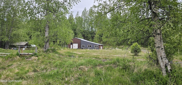 2514 E Sleepy Hollow Cir, Wasilla, AK 99654 - view of yard featuring an outbuilding, an outdoor structure, a garage, and a forest view