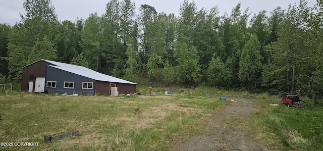 2514 E Sleepy Hollow Cir, Wasilla, AK 99654 - view of yard featuring a view of trees, a pole building, an outbuilding, and a garage