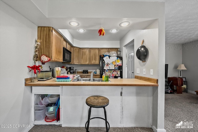 5320 Larkspur St, Anchorage, AK 99507 - kitchen with black microwave, range, a peninsula, carpet flooring, and brown cabinetry