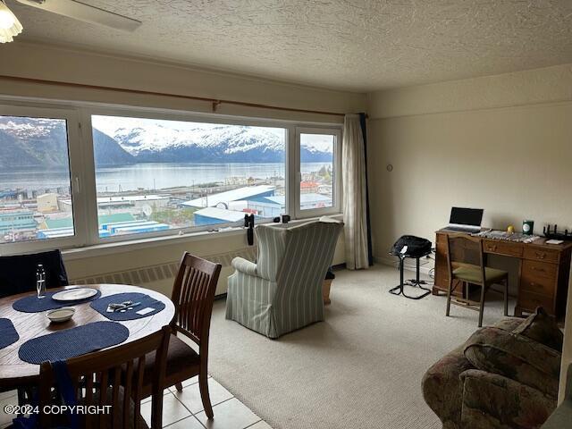 100 Kenai St # 908, Whittier, AK 99693 - dining room featuring a textured ceiling, an office area, light colored carpet, and light tile patterned flooring