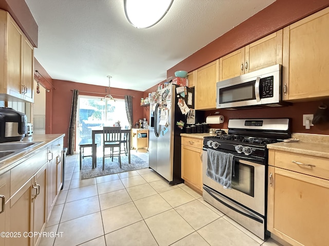 711 Maple Dr, Kenai, AK 99611 - kitchen with appliances with stainless steel finishes, light brown cabinets, light countertops, and light tile patterned floors